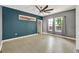 Light-filled bedroom with hardwood floors, large windows, and gray and blue accent wall at 506 Perkins St, Leesburg, FL 34748