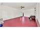 Large bonus room featuring a red concrete floor, white ceiling, and white walls at 506 Perkins St, Leesburg, FL 34748