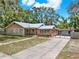 Inviting single-story home featuring a brick facade, gated driveway, and ample parking space at 506 Perkins St, Leesburg, FL 34748