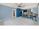 Bright kitchen featuring bold blue cabinets, modern tile flooring, and a unique ceiling fan at 506 Perkins St, Leesburg, FL 34748