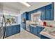 Spacious kitchen with stainless steel appliances, marble countertops, and bright blue cabinets at 506 Perkins St, Leesburg, FL 34748