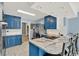 Open-concept kitchen with modern appliances, breakfast bar, and stylish blue cabinetry at 506 Perkins St, Leesburg, FL 34748
