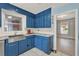 Charming kitchen features blue cabinetry, marble countertops, and a stainless steel sink at 506 Perkins St, Leesburg, FL 34748
