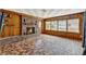 Rustic living room with a brick fireplace, wood paneling, and vintage-style flooring at 506 Perkins St, Leesburg, FL 34748