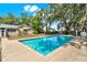 Outdoor pool area featuring a backyard pool surrounded by concrete, lush trees, and a partial view of the house at 506 Perkins St, Leesburg, FL 34748