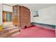 Cozy sunroom with a brick accent wall, red flooring, and a built-in bench seat under a window at 506 Perkins St, Leesburg, FL 34748