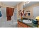 Bathroom features a shower with a patterned curtain, a toilet, a large mirror, and neutral striped wallpaper at 506 Weston Manor Dr, The Villages, FL 32162
