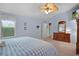 Relaxing bedroom featuring blue walls, large windows, carpet floors, and an ensuite bathroom entrance at 506 Weston Manor Dr, The Villages, FL 32162
