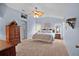 Cozy bedroom with blue walls, carpet flooring, ceiling fan, and large windows with natural light at 506 Weston Manor Dr, The Villages, FL 32162