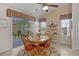 Cozy dining area features a round wooden table, red cushioned chairs, and natural light from sliding glass doors at 506 Weston Manor Dr, The Villages, FL 32162