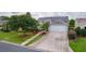 Exterior view of a well-maintained home, showcasing the driveway, landscaping, and architectural details at 506 Weston Manor Dr, The Villages, FL 32162