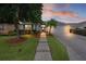Charming home featuring a manicured lawn, mature trees, and a walkway leading to the front door at 506 Weston Manor Dr, The Villages, FL 32162