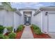 Inviting entryway with a modern front door, manicured shrubs, and clean architectural lines at 506 Weston Manor Dr, The Villages, FL 32162