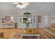 Bright living room features a ceiling fan, entertainment center, and hardwood floors at 506 Weston Manor Dr, The Villages, FL 32162