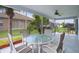 Charming screened-in patio featuring a round glass-top table with chairs, ceiling fan, and serene backyard views at 506 Weston Manor Dr, The Villages, FL 32162