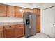 Well-lit kitchen featuring stainless fridge, wood cabinets, and ample counter space at 507 Ventura Ct, The Villages, FL 32159