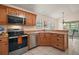 Kitchen featuring stainless steel appliances, wood cabinets, and ample counter space at 507 Ventura Ct, The Villages, FL 32159