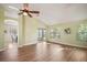 Open floor plan, features new wood flooring, large windows, ceiling fan, and access to the screened in porch at 507 Ventura Ct, The Villages, FL 32159