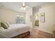 Bright main bedroom with a ceiling fan, wooden floors, and ensuite bathroom at 507 Ventura Ct, The Villages, FL 32159