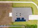 Bird's-eye view of a house with a brown roof, solar panels, and a concrete patio surrounded by green grass at 5354 Travertine St, Mount Dora, FL 32757