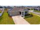 Aerial view of single Gathering home with solar panels and a well manicured lawn at 5354 Travertine St, Mount Dora, FL 32757