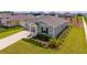 Aerial view of a home with manicured lawn, landscaping, and three-car garage at 5354 Travertine St, Mount Dora, FL 32757