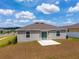 The home's exterior has a small concrete patio and sliding glass door leading to a grassy backyard at 5354 Travertine St, Mount Dora, FL 32757