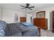 Well-lit bedroom features carpet, a ceiling fan, and wooden dresser, offering ample storage and a view to the kitchen at 5354 Travertine St, Mount Dora, FL 32757