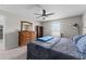 Bright bedroom with ceiling fan, carpet, and wooden dresser, complemented by natural light and a functional layout at 5354 Travertine St, Mount Dora, FL 32757