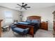 Spacious bedroom featuring a large window, a ceiling fan, carpet, and a wooden bed frame with stylish blue accents at 5354 Travertine St, Mount Dora, FL 32757