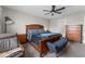 Bedroom with ceiling fan, wooden furniture including bed frame and nightstands, with a cozy seating area and view to bathroom at 5354 Travertine St, Mount Dora, FL 32757
