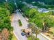A landscaped community entrance is surrounded by mature trees and a guard house at 5354 Travertine St, Mount Dora, FL 32757