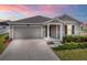 Charming single-Gathering home featuring a gray exterior, well-kept landscaping, and an attached two-car garage at 5354 Travertine St, Mount Dora, FL 32757