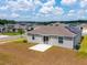 An exterior view of a single-Gathering home with a patio, solar panels, and a well-manicured lawn at 5354 Travertine St, Mount Dora, FL 32757