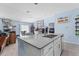 Kitchen island with a double sink and stainless dishwasher overlooking living and dining areas at 5354 Travertine St, Mount Dora, FL 32757