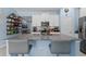 Kitchen with breakfast bar with seating, white cabinetry and stainless appliances at 5354 Travertine St, Mount Dora, FL 32757