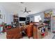 Spacious living room with brown leather furniture, tv, ceiling fan and decor at 5354 Travertine St, Mount Dora, FL 32757