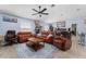 Open-concept living room with leather couches, ceiling fan, and tile floors at 5354 Travertine St, Mount Dora, FL 32757