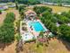Aerial view of a community pool area with lounge chairs, umbrellas, and mature landscaping at 5354 Travertine St, Mount Dora, FL 32757
