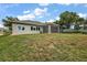 Exterior of home with a screened-in lanai, a spacious backyard, and lush green grass at 562 Dowling Cir, Lady Lake, FL 32159