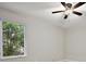 Bright bedroom with modern ceiling fan and view to outside greenery at 562 Dowling Cir, Lady Lake, FL 32159