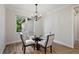 Bright dining room with a glass table, four chairs, modern chandelier, and large window for natural light at 562 Dowling Cir, Lady Lake, FL 32159