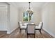 Bright dining room with a glass table, four chairs, modern chandelier, and large window for natural light at 562 Dowling Cir, Lady Lake, FL 32159