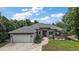 Beautiful single-story home featuring stone accents, a spacious two-car garage, and meticulously landscaped front yard at 562 Dowling Cir, Lady Lake, FL 32159
