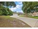 Inviting single-story home with a long driveway, a two-car garage, manicured landscaping, and a large shade tree at 562 Dowling Cir, Lady Lake, FL 32159