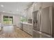 Spacious kitchen features stainless steel appliances, white cabinetry, and a view to the backyard patio at 562 Dowling Cir, Lady Lake, FL 32159