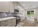 Well-lit kitchen featuring stainless steel appliances, white cabinets, and marble countertops with a view to the backyard at 562 Dowling Cir, Lady Lake, FL 32159