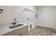 Functional laundry room with sink, marble countertop, and ample storage at 562 Dowling Cir, Lady Lake, FL 32159