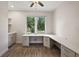 Well-lit home office with a large desk, wood floors, and a view of the neighborhood street at 562 Dowling Cir, Lady Lake, FL 32159