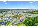 Aerial view of a neighborhood showcasing beautiful homes with a community lake and lush landscaping, indicated with a marker at 6988 Lawrenceville Way, The Villages, FL 34762